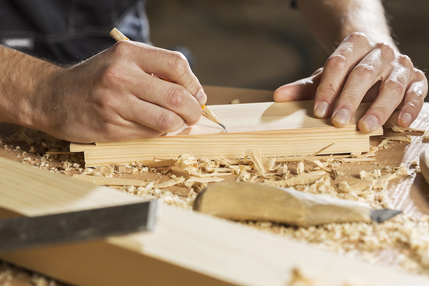 Tischlermeister bei der Feinarbeit an einem Werkstück aus Massivholz